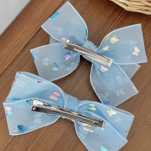 Pair of light blue mesh bow hair clips with glitter butterfly patterns and metal clips