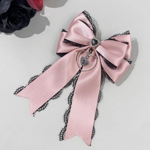 Detail der rosa Satin-Schleife Haarspange mit schwarzer Spitze und Herzanhänger im Gothic-Stil