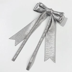 Elegant shiny silver satin bow hair clip with long metallic tassels for a princess look