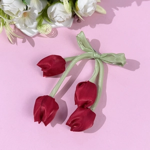 Dettaglio del fermaglio per capelli a tulipano in raso rosso con fiocco verde