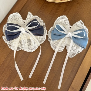 Détail de barrettes noeud en denim avec perles, bordure en dentelle et longs rubans