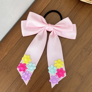 Nœud de cheveux en satin rose avec broderie florale et longs rubans sur bois