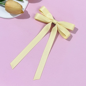 Close-up of light yellow ballet ribbon hair clip with elegant long streamers on lavender