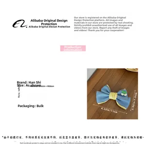 Détail de la pince à cheveux en denim bleu avec ruban jaune et motif cerise brodé