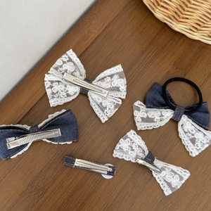 5-delige set van blauwe denim en witte kant haarclips en scrunchie op houten achtergrond