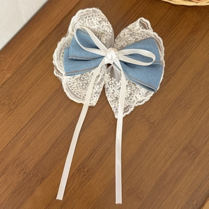 Détail de la pince à cheveux en denim et dentelle florale avec perle et longs rubans