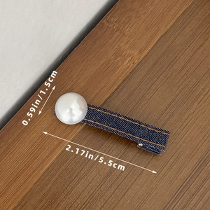 Detail van denim haarspeld met gele stiksels en parel, maat 5,5 cm bij 1,5 cm