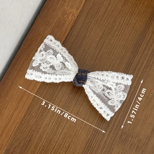 Detailweergave van de afmetingen van 8 cm bij 4 cm van de kanten en denim haarspeld strik