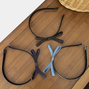 Three-piece denim bow headband set in dark, navy, and light blue on a wooden surface