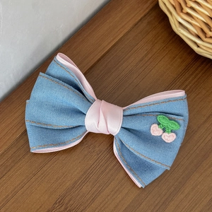 Nahaufnahme der Jeans-Haarschleife mit rosa Kirschedelstickerei und Satinfutter