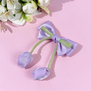 Dettaglio del fermaglio per capelli a fiocco in raso viola con ciondoli a tulipano