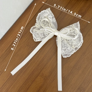 Fermaglio per capelli in pizzo beige con perle, misura 21x14,5 cm su fondo di legno caldo
