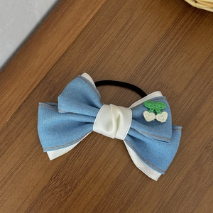 Détail d'un nœud papillon en denim avec broderie de feuilles et doublure satin