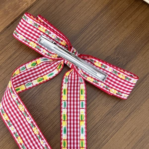 Barrette à cheveux avec nœud à fleurs et motif à carreaux rouges sur fond de bois
