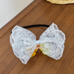 Eleganter hellblauer Spitzenbogen Haarreif mit Stickerei auf einem Holzuntergrund