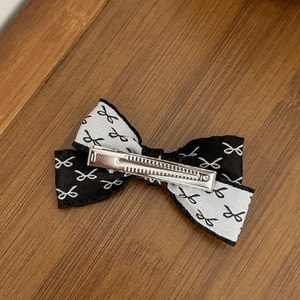 Pince à cheveux nœud bicolore à volants avec motifs floraux noirs et base en métal argenté