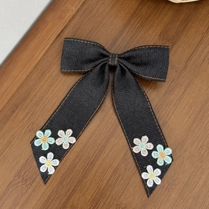 Détails du nœud en denim pour cheveux avec coutures orange et motifs floraux brodés