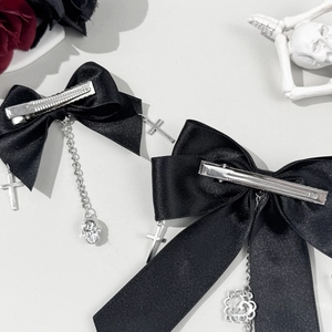 Barrettes gothiques à nœuds noirs avec breloques croix et crâne argentés sur fond gris