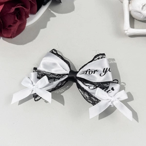 Close-up of lace bow hair clip with black 'for you' print and satin ribbon texture
