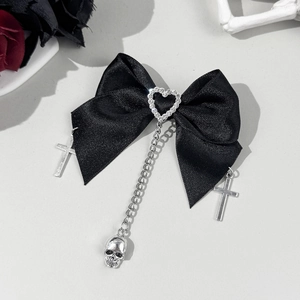 Détail d'une pince à cheveux gothique noire avec croix en argent et chaîne à crâne
