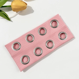 Close-up of pink ribbed knit headband featuring 8 silver metal grommets for punk style