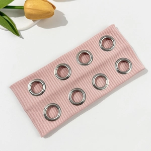 Detail of pink ribbed knit headband featuring silver metal grommets and punk style