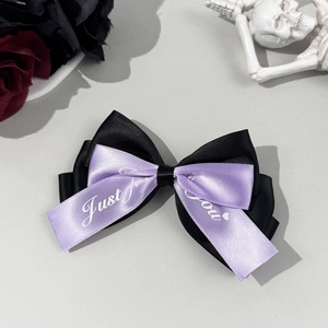 Detail of Gothic bow hair clip in black and lavender ribbon with Just for you print