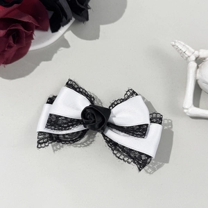 Détail d'une pince à cheveux gothique avec rose en tissu noir, dentelle et rubans