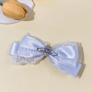 Detail van lavendel kant strik haarclip met zilveren hart juweel en parel accent