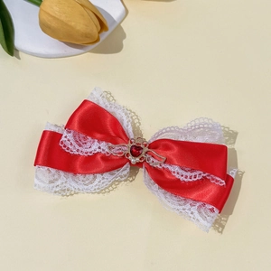 Detailweergave van Lolita haarclip met rode satijnen strik, kant en hartvormige steen