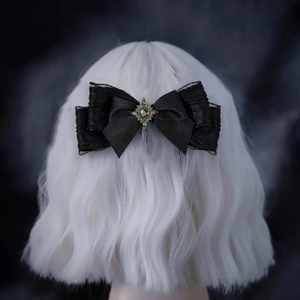 Close-up of black lace bow hair clip with vintage metal center and crystal gemstone
