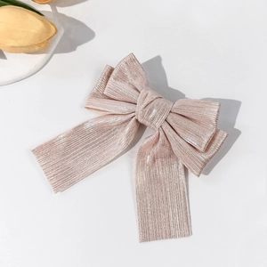 Sparkling champagne gold bow hair clip with textured fabric and long ribbon streamers