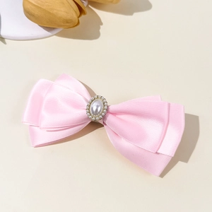Süße rosa Satin-Schleifen-Haarspange mit Perle und Diamant-Akzenten auf weißem Hintergrund