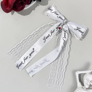 Barrette nœud en dentelle blanche avec main de squelette rose et ruban décoratif