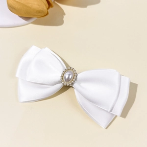 Nahaufnahme einer eleganten weißen Satinschleifen-Haarklammer mit Perle und Strass