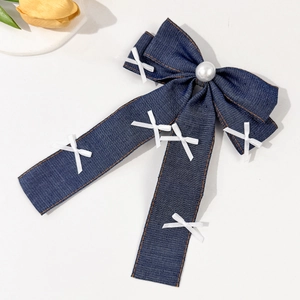 Detail der Denim-Haarspange mit weißen Perlen und feinen Schleifenstickereien-Akzenten