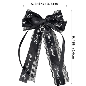 Détail de la dentelle, ruban Just for you et pendentif cœur sur une pince à nœud noir