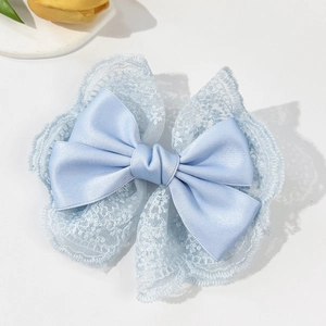 Detailed view of light blue lace and satin bow hair clip with intricate textures