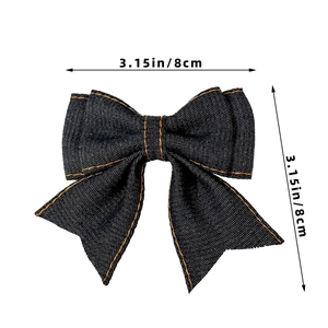 Detail of 3.15-inch dark blue denim bow hair clip with orange contrast stitching