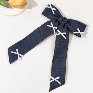 Detailansicht der dunkelblauen Denim-Haarschleife mit orangefarbenen Ziernähten