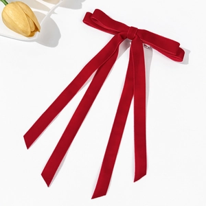 Fiocco per capelli in velluto rosso con nastri lunghi su sfondo bianco minimale