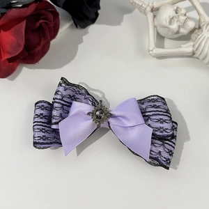 Gothic purple satin bow hair clip with black lace and vintage gem on white background