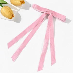 Vista dettagliata del fiocco per capelli in velluto rosa con lunghi nastri e tulipano
