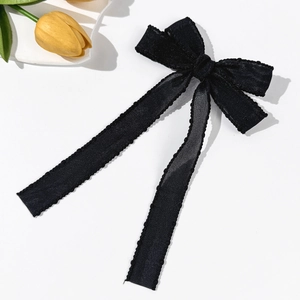 Detailed close-up of a black mesh bow hair clip with elegant lace edges and ribbons