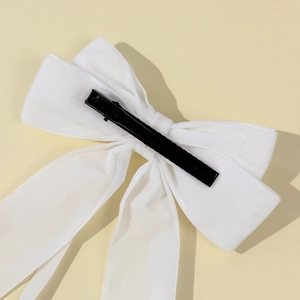 Elegant white velvet bow hair clip with long streamers and a black metal duckbill hair clip