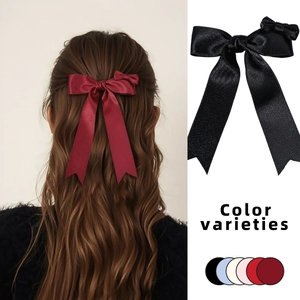 Detailed view of large satin bow hair clip with secondary mini bow in various colors