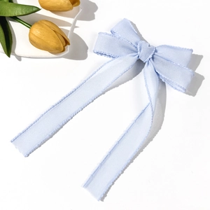 Light blue mesh bow hair clip with long ribbons and yellow tulip decor on white background