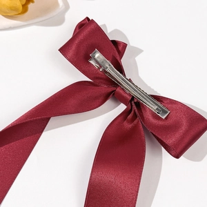 Elegant burgundy satin bow hair clip with silver metal spring fastener shown on back
