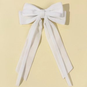 Detail view of multi-layered white velvet bow hair clip with long elegant streamers