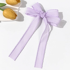 Close-up of lilac mesh ribbon hair clip with wavy stitching and elegant long streamers